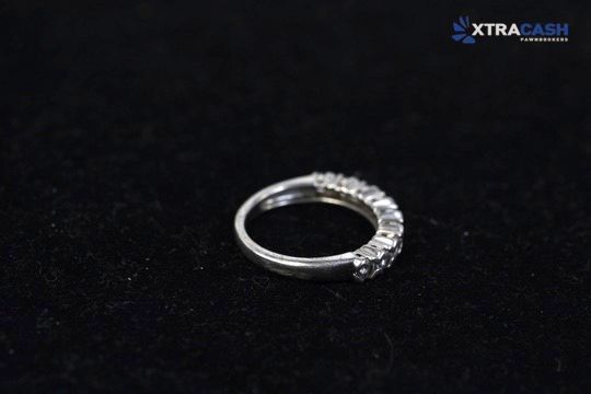 Silver ring with clear gemstones on a black background