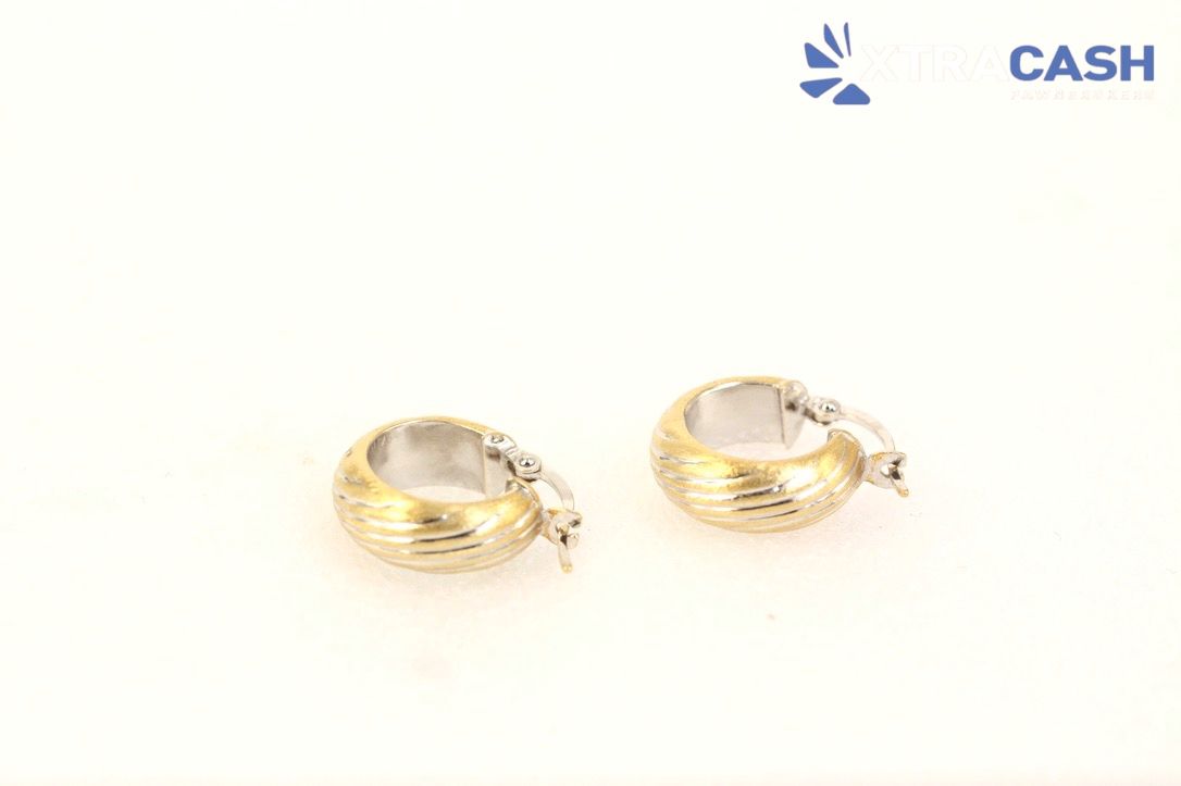 Two gold hoop earrings on a white background
