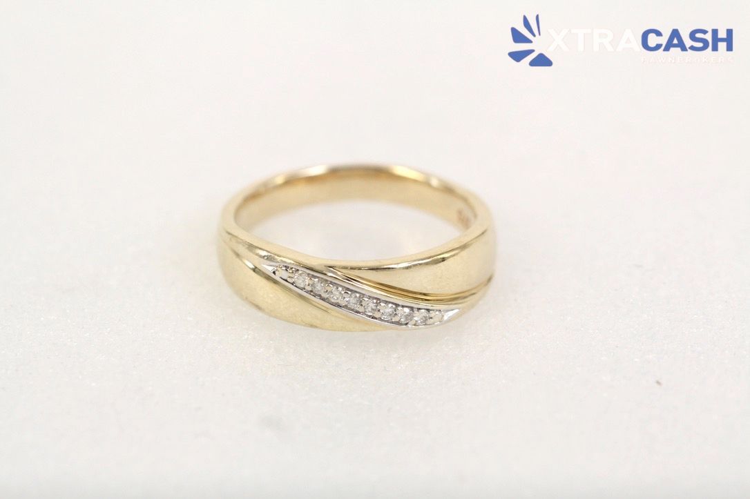 Gold ring with a diagonal row of small clear stones on a white background