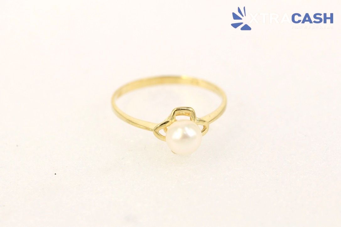 Gold ring with a pearl flower design on a white background
