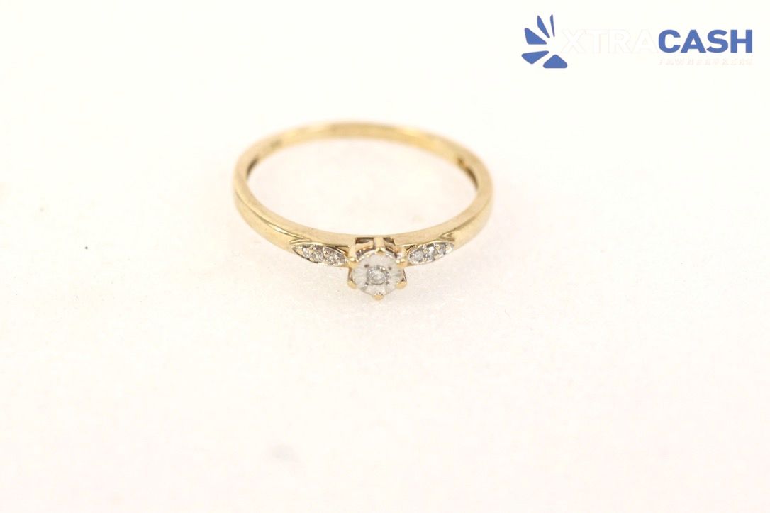 Gold ring with a central diamond on a white background