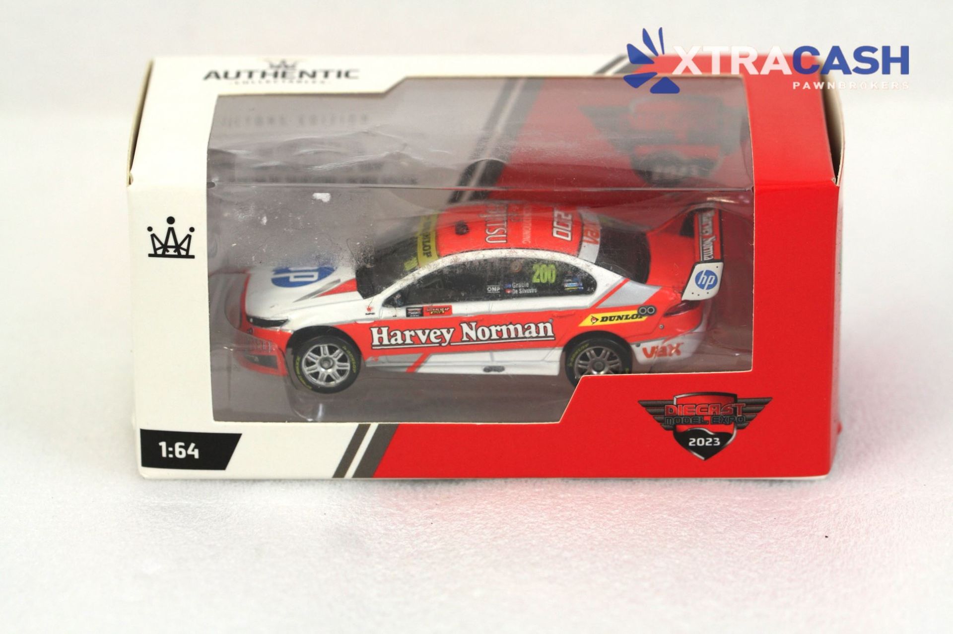 Red and white racing toy car in a clear display box with XTRACASH branding