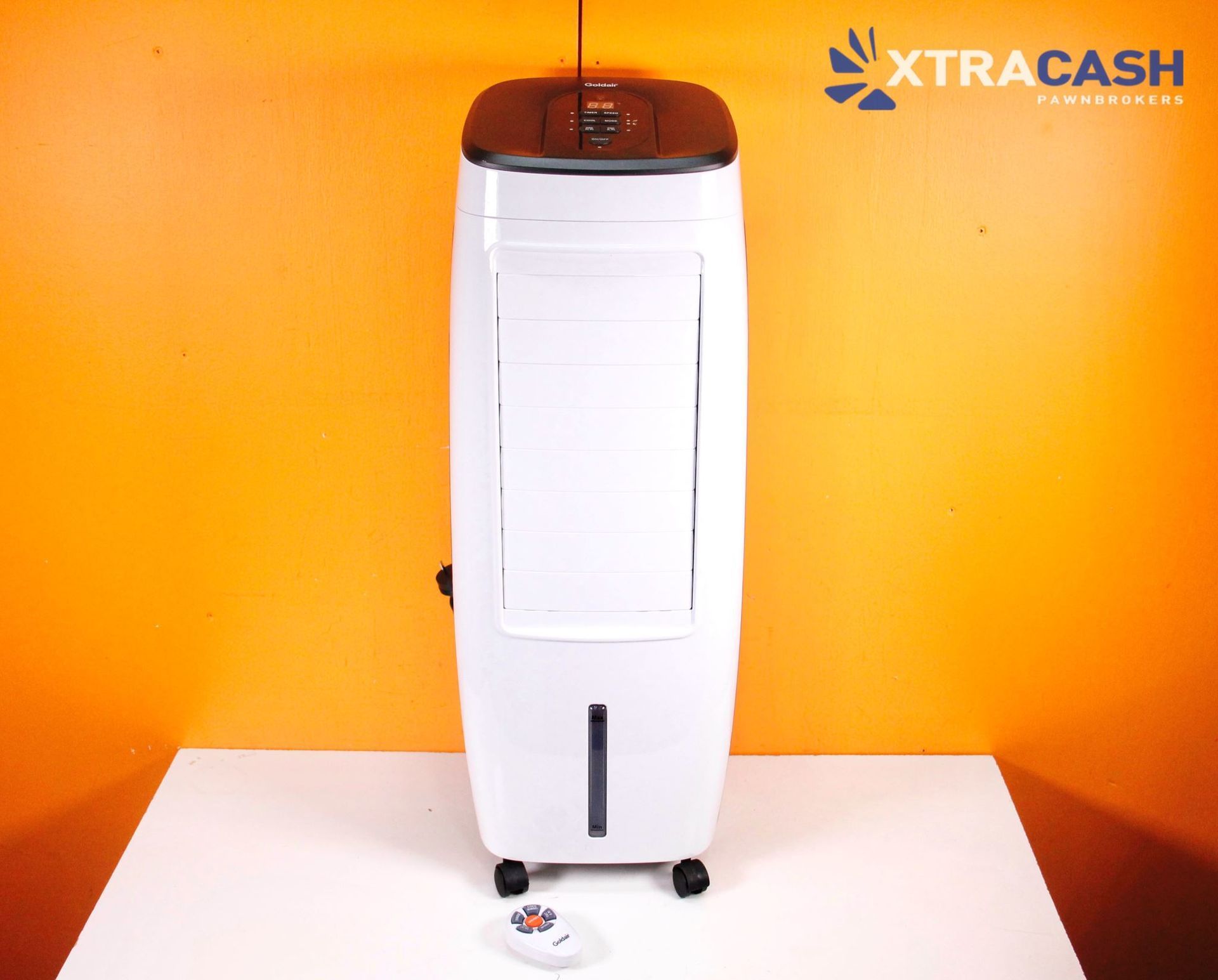 White portable air cooler on a white table against an orange wall