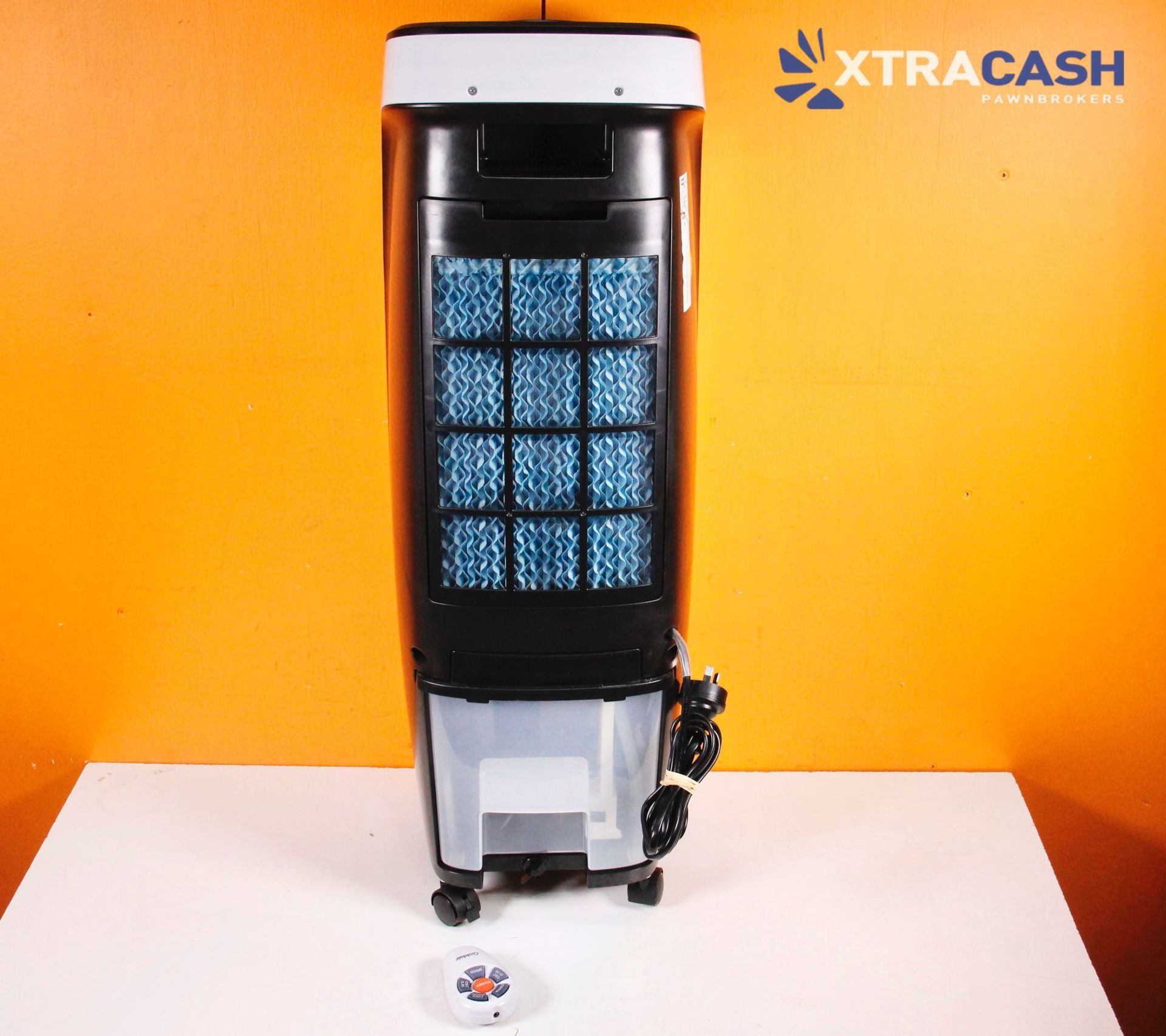 White portable air cooler on a white table against an orange wall