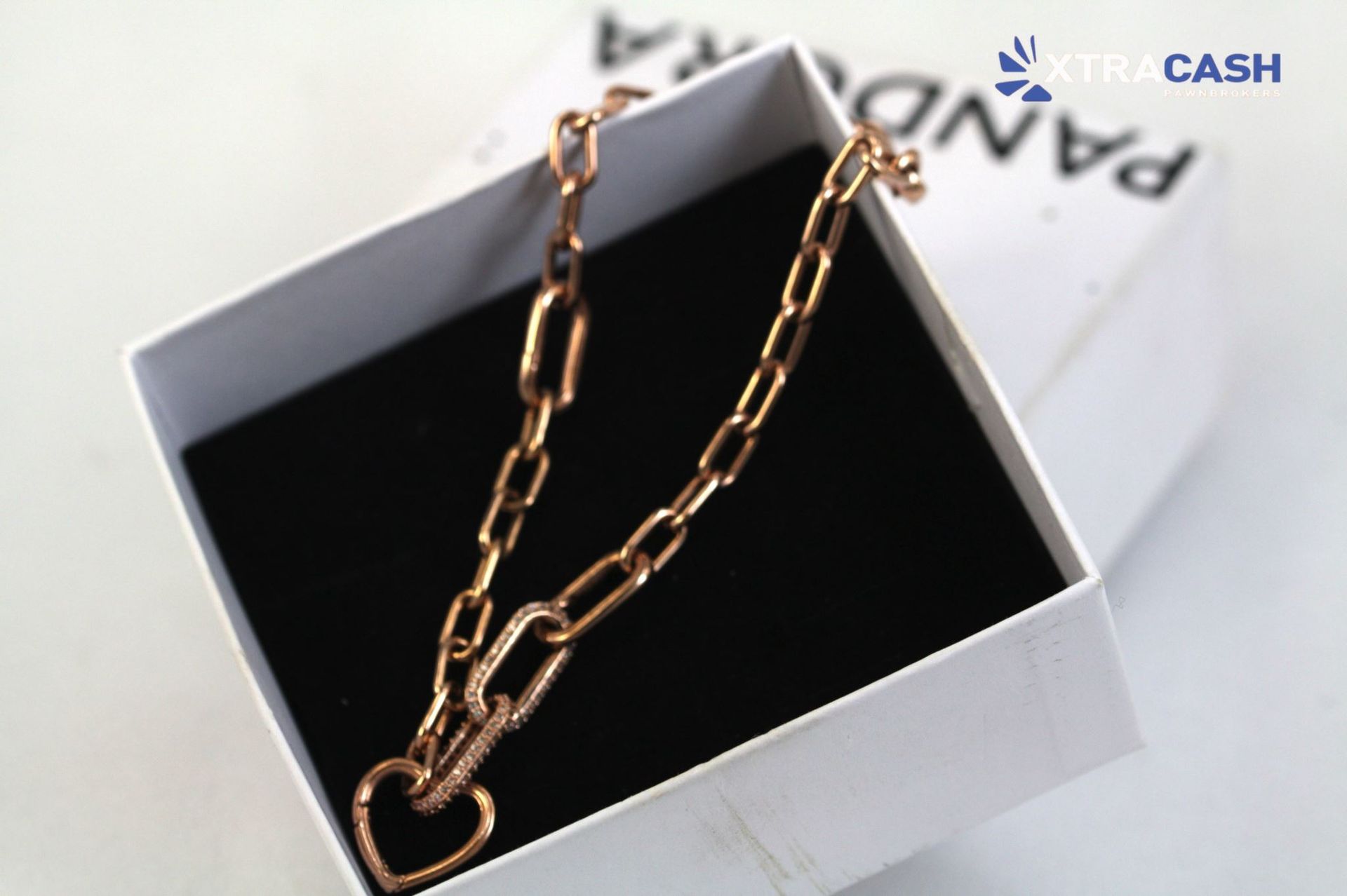 Gold heart pendant necklace in a white gift box on a black insert