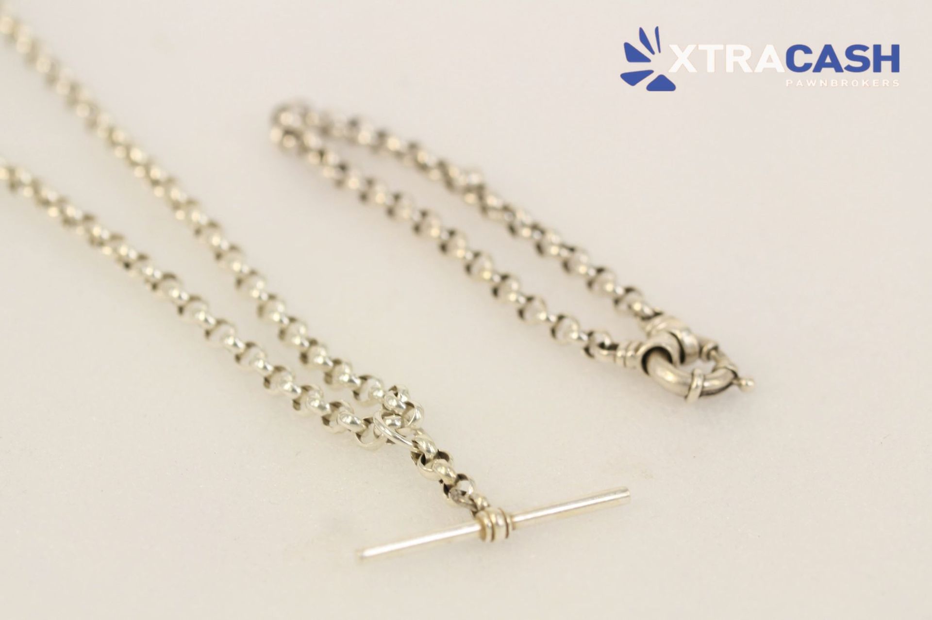 Two silver chain necklaces on a light background, one with a T-bar clasp and one with a heart clasp