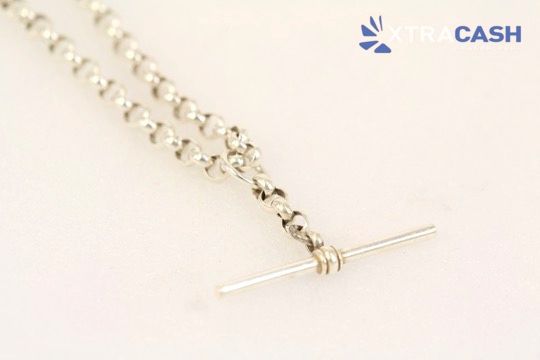 Two silver chain necklaces on a light background, one with a T-bar clasp and one with a heart clasp