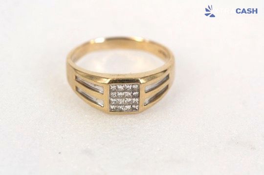 Gold ring with three silver-stone panels on a white background