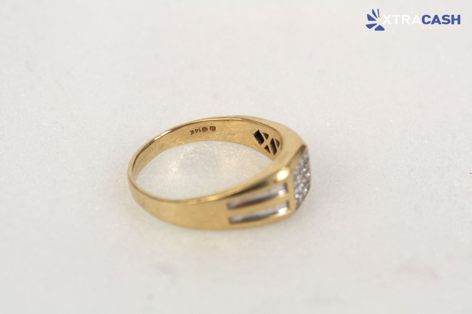 Gold ring with three silver-stone panels on a white background