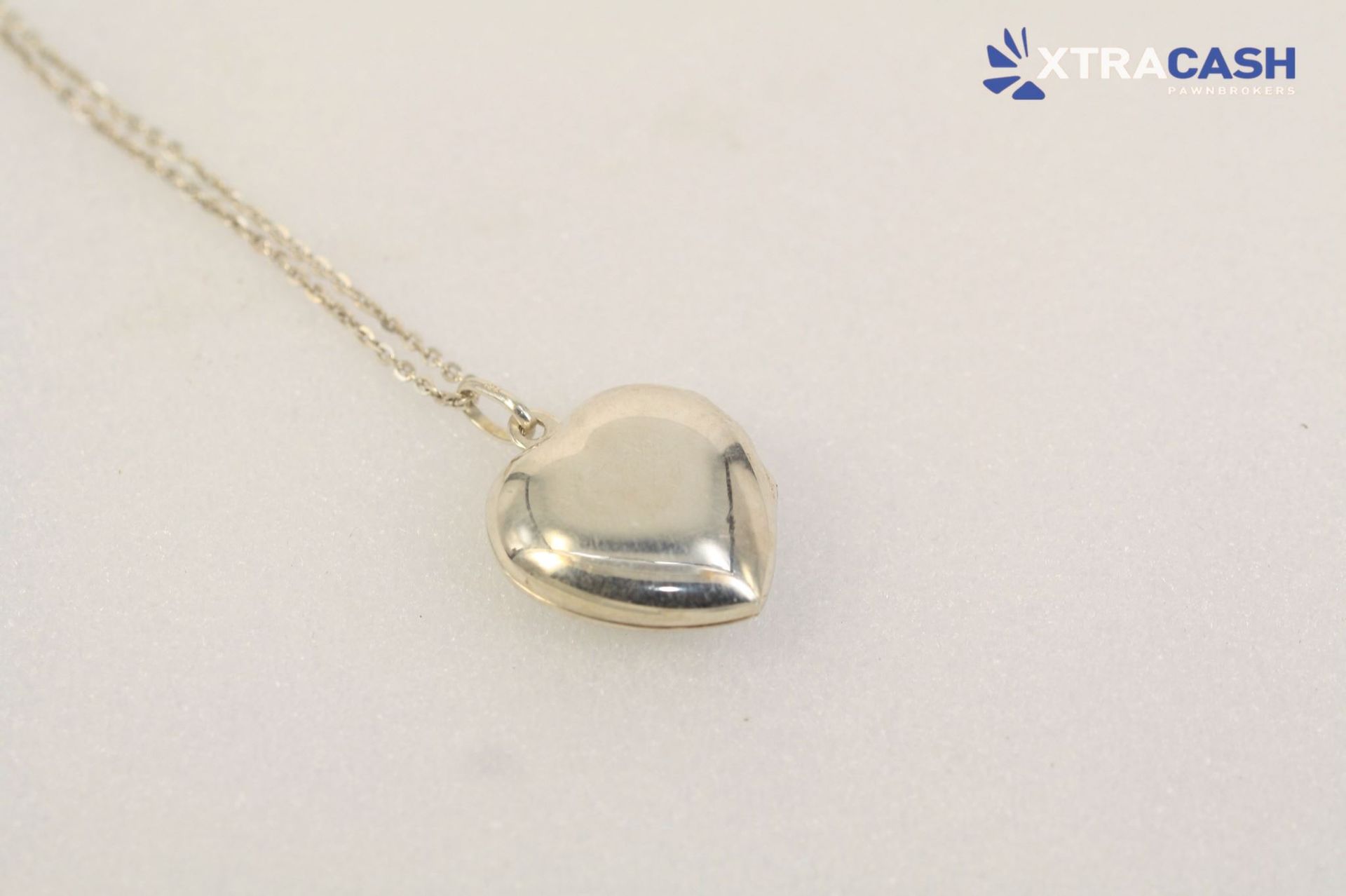 Silver heart pendant necklace on a light background