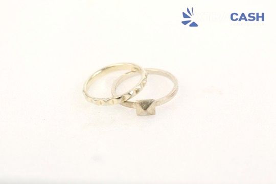 Two gold rings on a white background with a small CASH logo in the top right.
