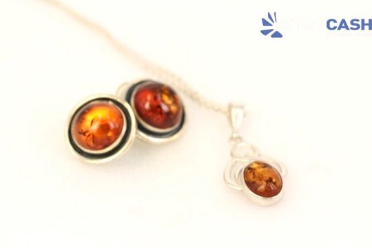 Amber gemstone pendant necklace with three round orange-brown stones on a silver chain