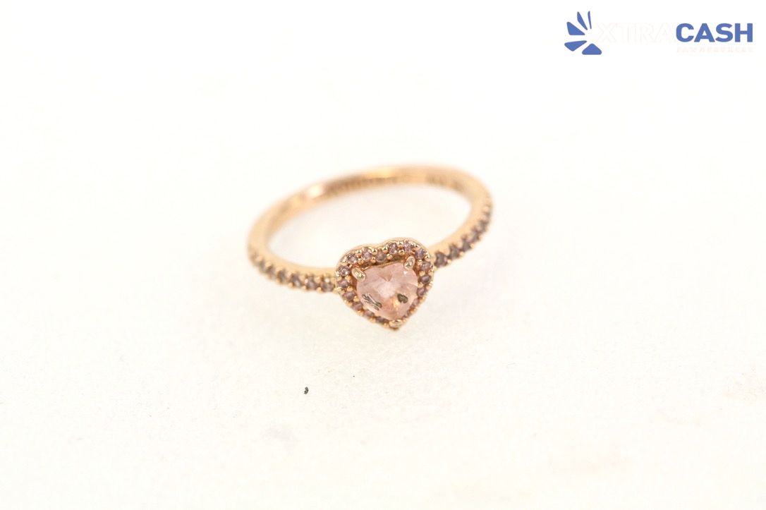 Rose gold heart-shaped ring on a white background with a small CASH logo in the corner