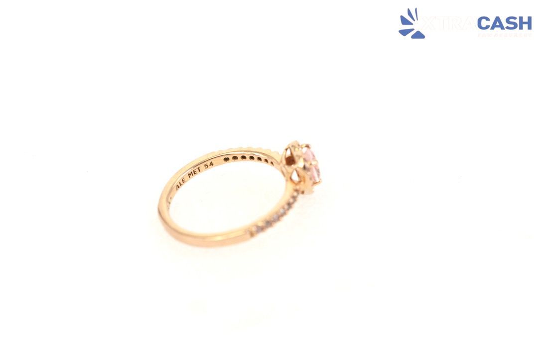 Rose gold heart-shaped ring on a white background with a small CASH logo in the corner