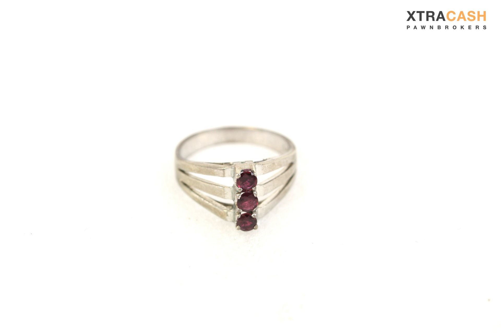 Gold ring with two red gemstones and a V-shaped silver accent on a white background