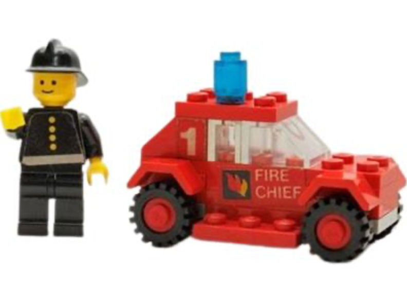 LEGO firefighter minifigure beside red fire chief truck with blue light