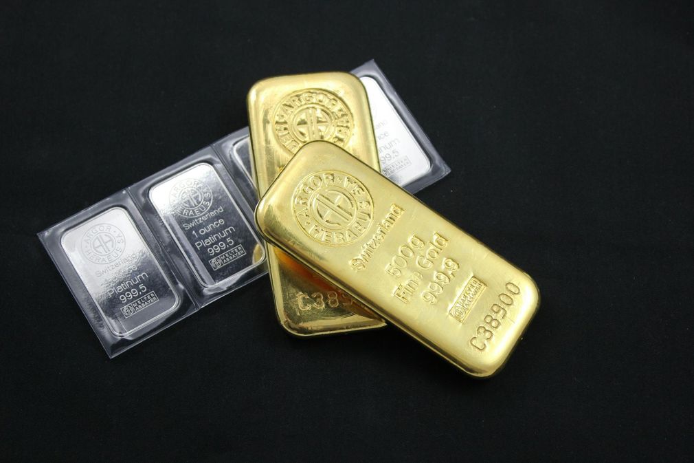 Gold and silver bullion bars stacked on a dark background