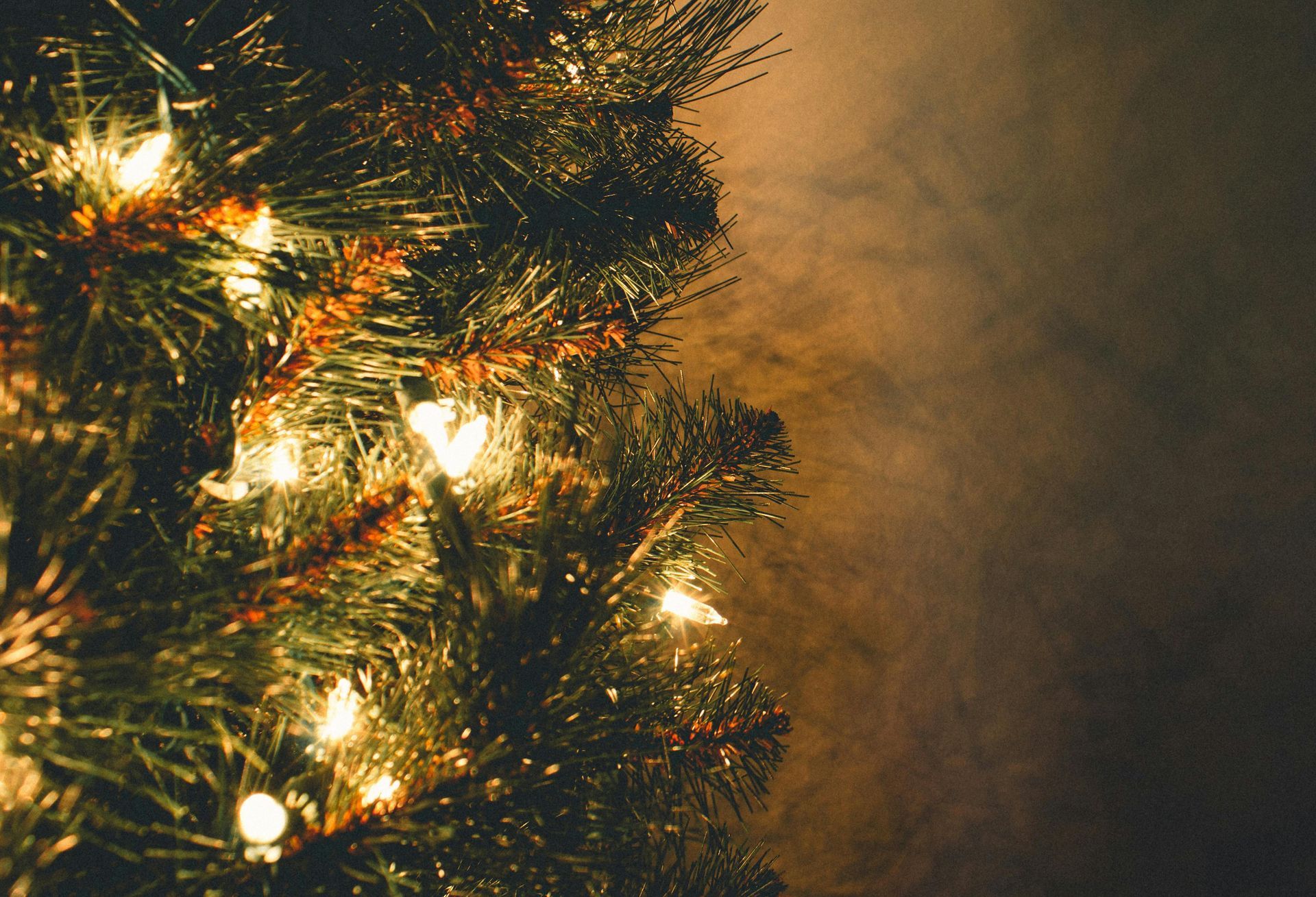 Christmas tree illuminated with white lights against a dark background.