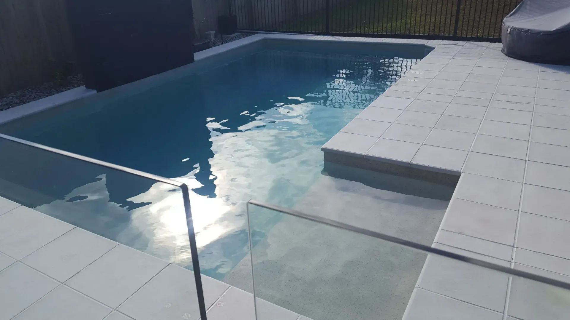 A Large Swimming Pool With A Glass Fence Around It — Tropical North Swimming Pools 'n' Spas In Currajong, QLD