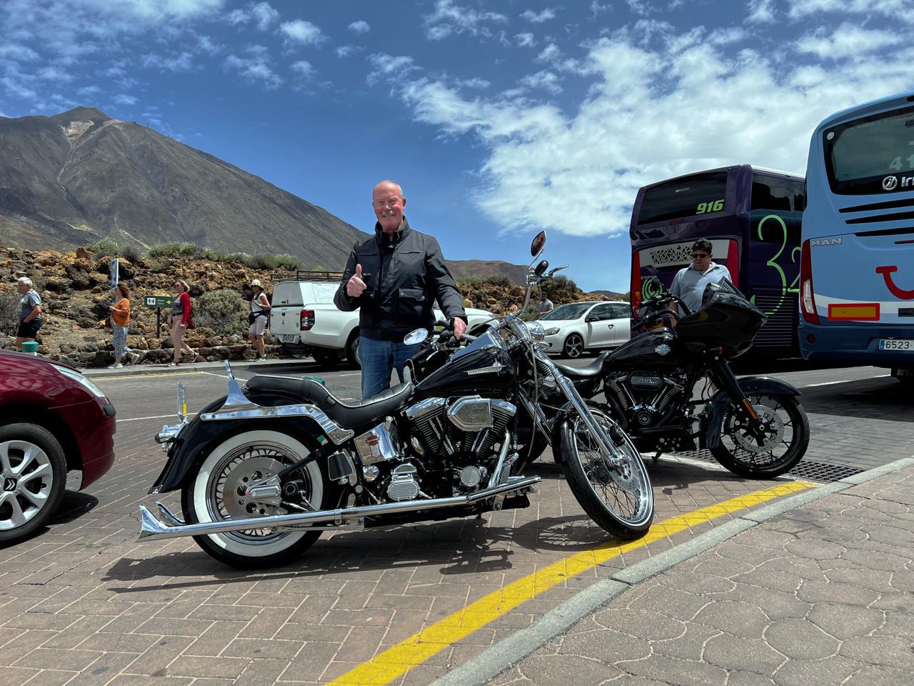A man is standing next to a motorcycle and giving a thumbs up.