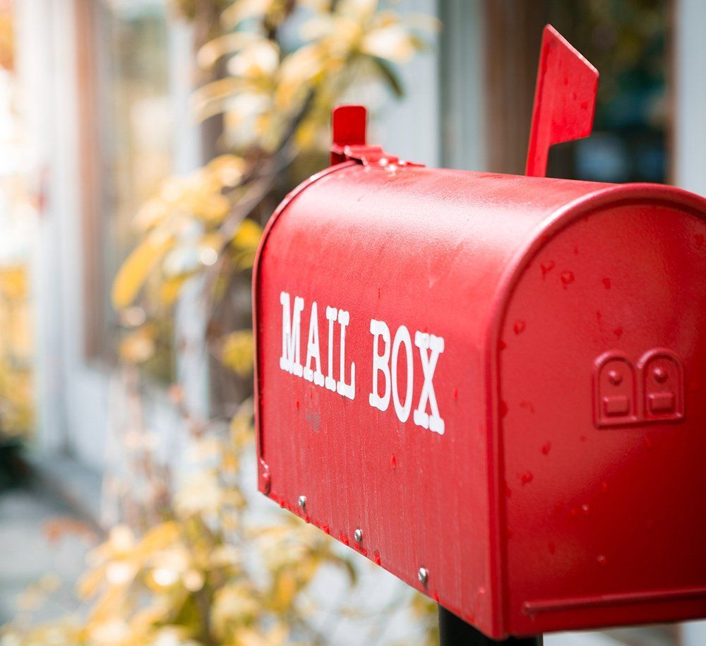 A red mailbox with the word mail box on it
