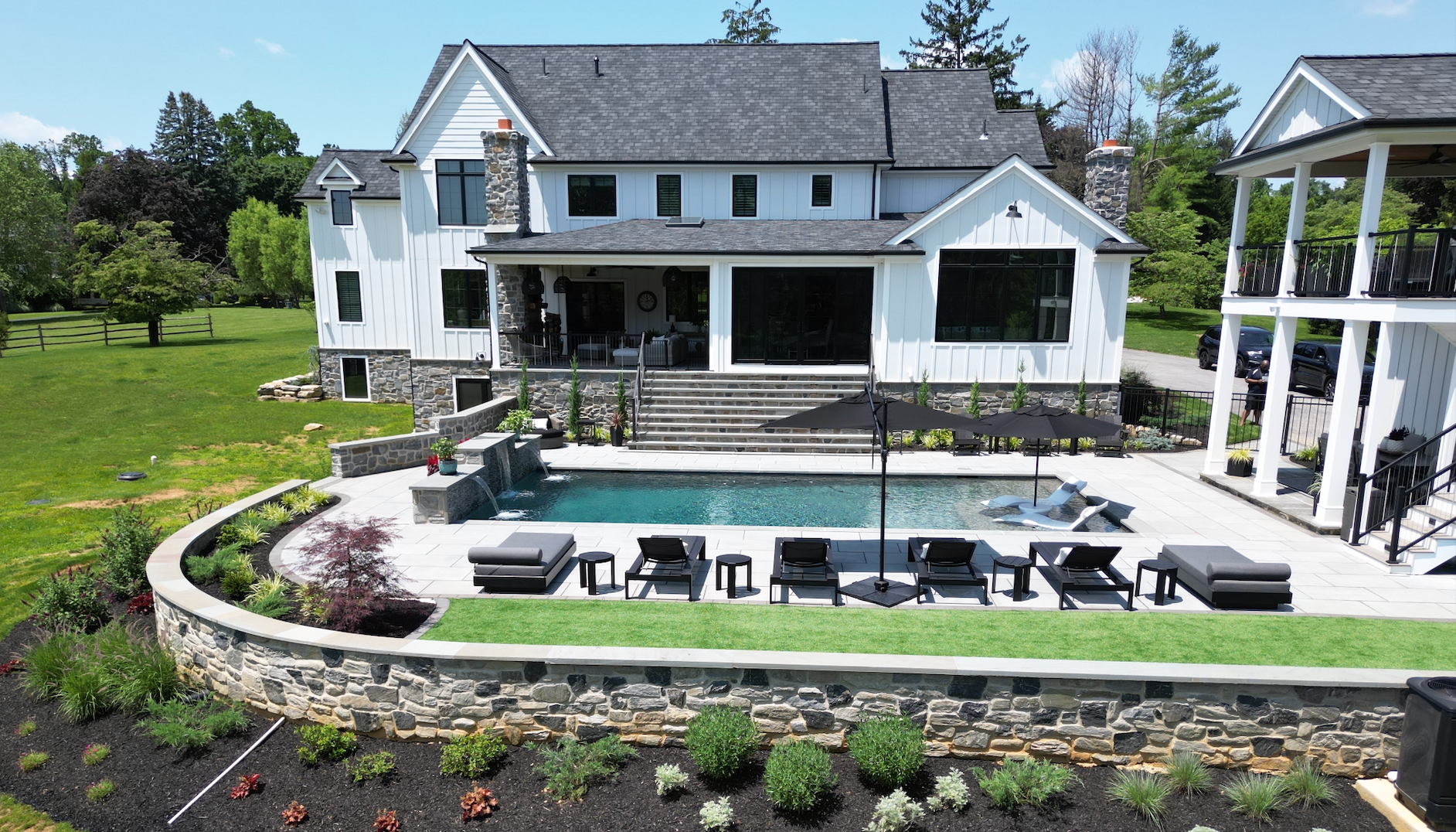 A living room with a couch , table , chairs and a pool.