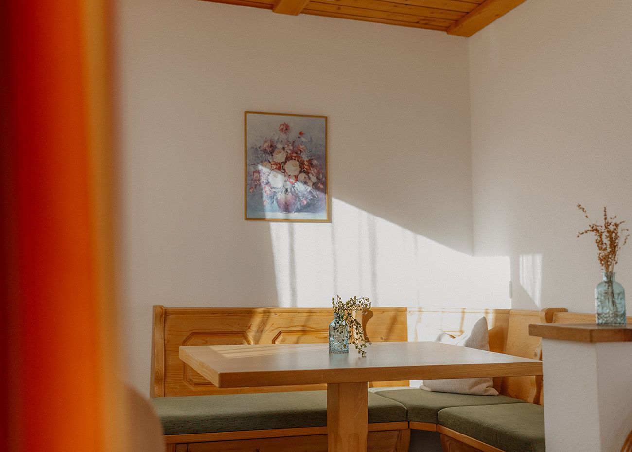 Gemütliche Essecke im alpenländischen Stil mit einer Eckbank aus Massivholz, gepolsterten Sitzen, einem passenden Esstisch
