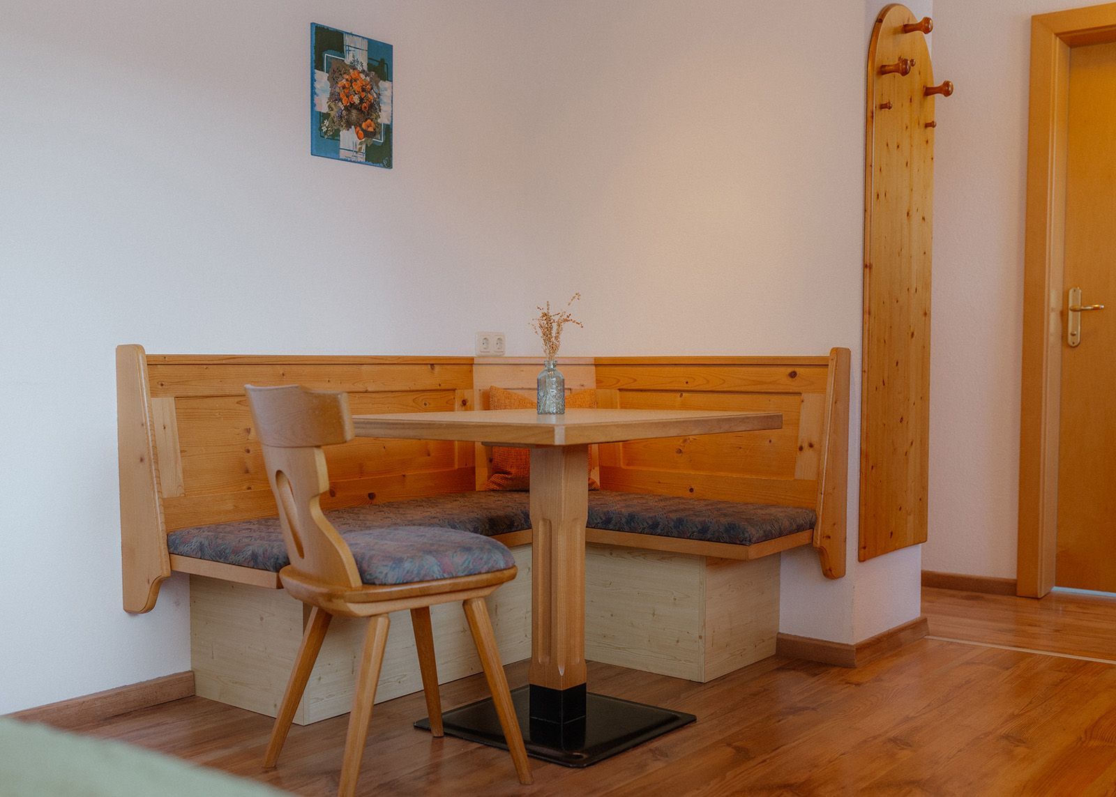 Gemütliche Essecke im alpenländischen Stil mit einer Eckbank aus Massivholz, gepolsterten Sitzen, einem passenden Esstisch
