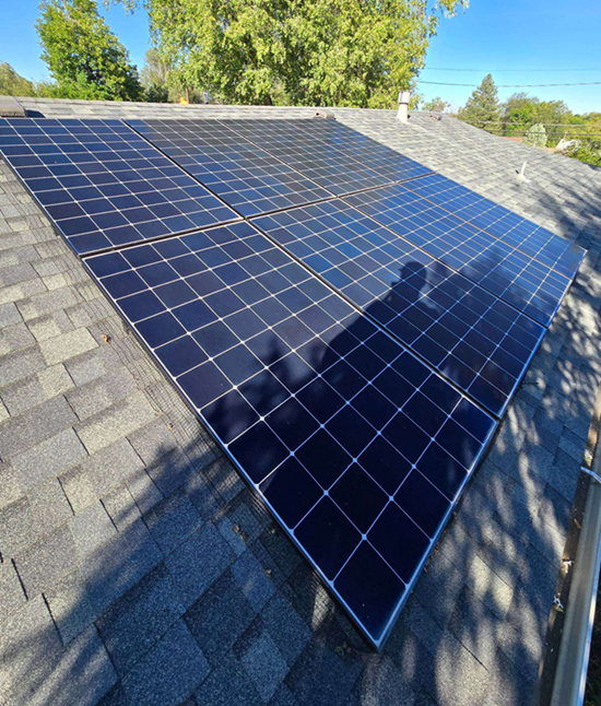 Solar panels installed on a residential roof, reflecting the sky.