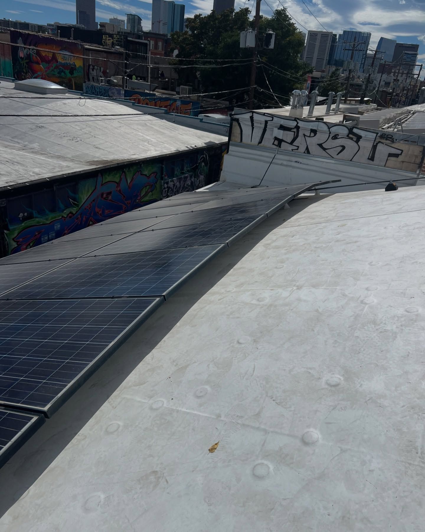 A white roof with solar panels and graffiti on it