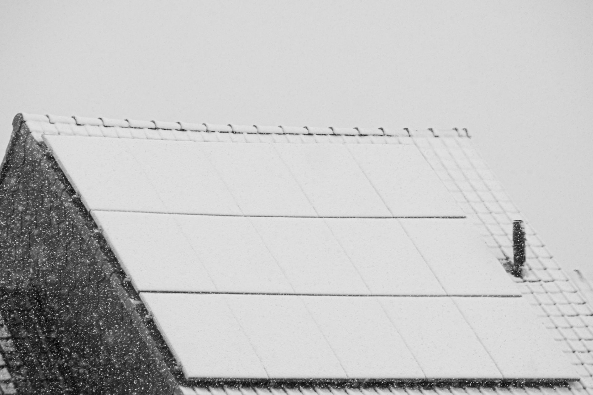 A black and white photo of a snowy roof