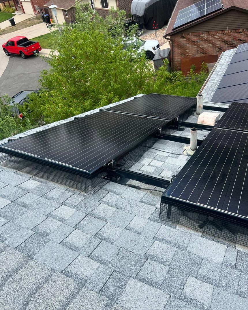 A row of solar panels on the roof of a house.