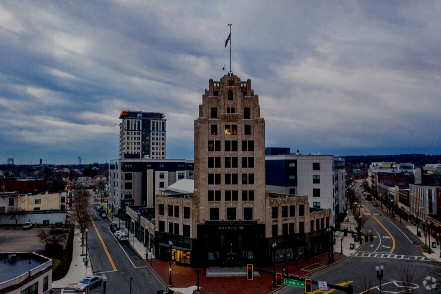 Downtown cityscape with a central historic tower at dusk under cloudy skies