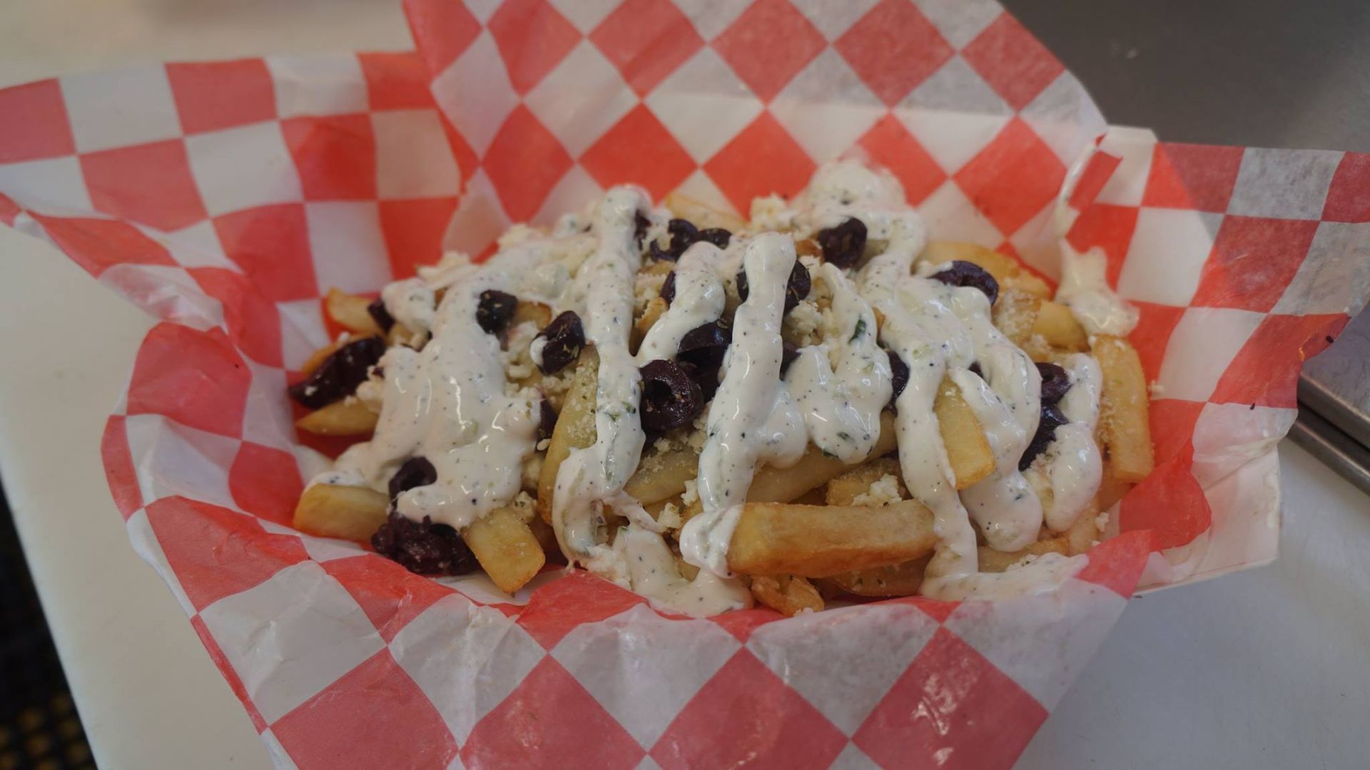 A close up of a plate of food on a checkered paper on a table.
