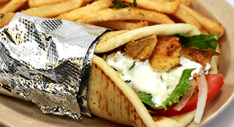 A gyro sandwich with french fries on a plate.