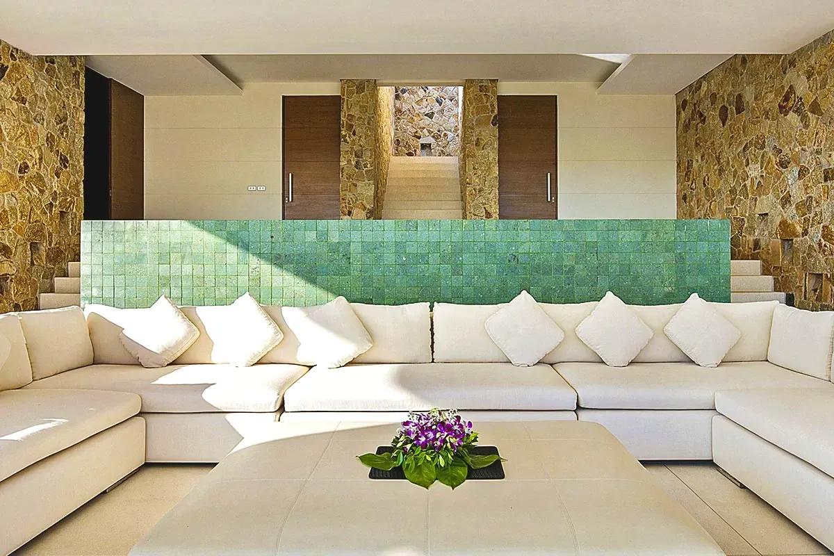 Sofá modular branco com parede de destaque revestida de hijau Artemano. 