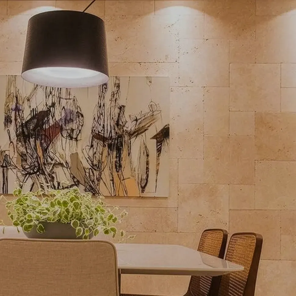 Sala de jantar com parede revestida com Travertino em estilo french pattern Artemano.