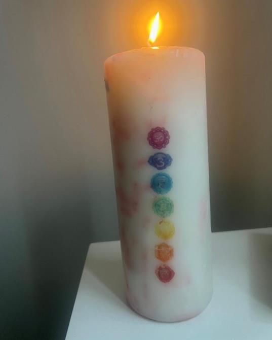 A candle with a rainbow design on it is sitting on a table.