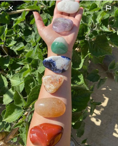 A person is holding a row of stones on their arm