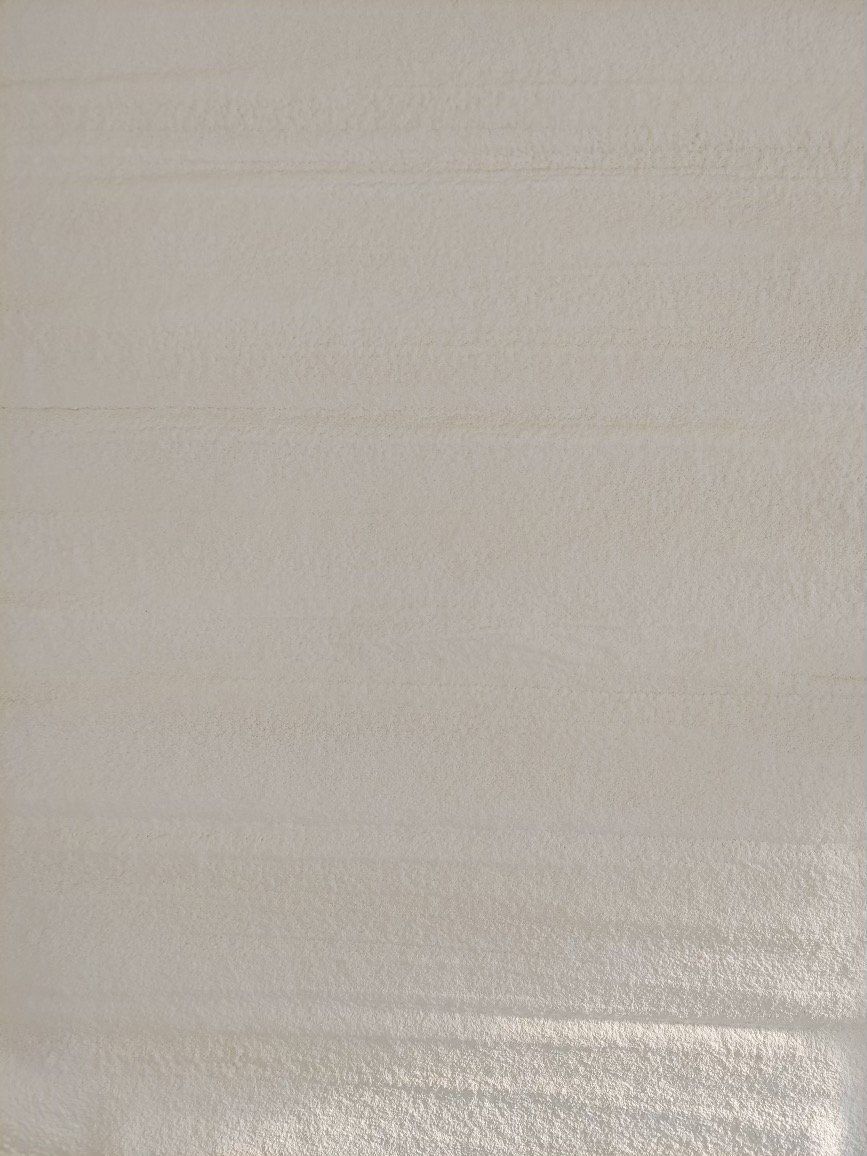 A light gray or off-white surface with subtle horizontal brushstroke textures.