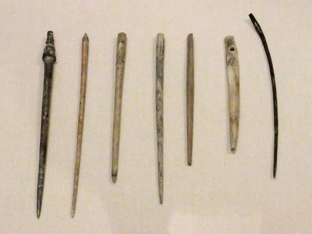 a row of wooden pins are lined up on a white surface