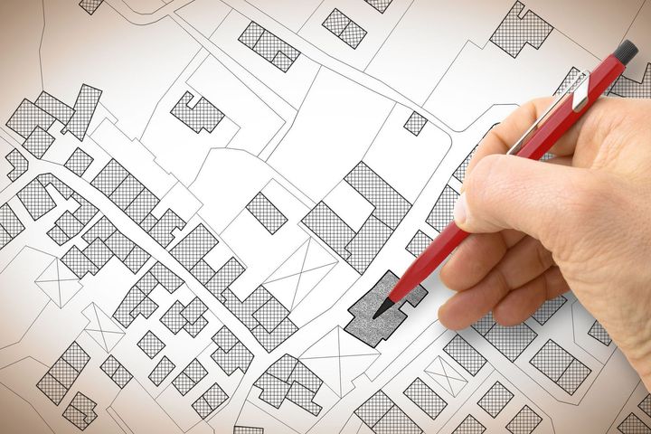 A person is drawing a map with a red pen