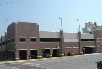 A large brick building with a lot of windows is next to a street.