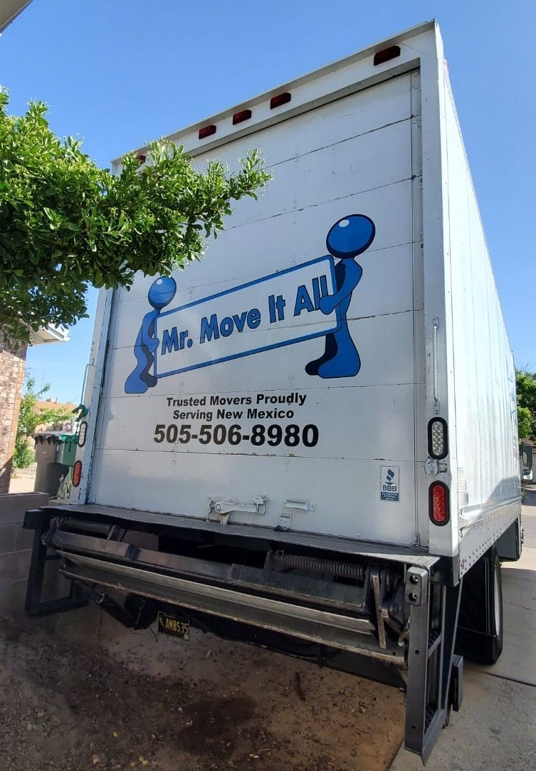 A mr. move it all truck is parked on the side of the road