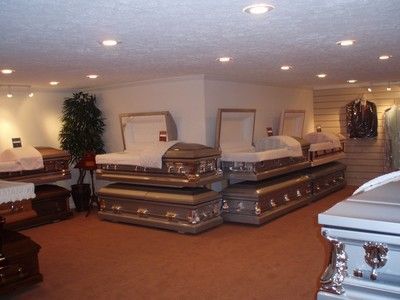 Furniture showroom with several mattresses on display under recessed ceiling lights.