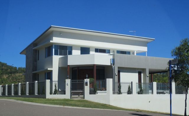 A large white house with a blue mailbox in front of it