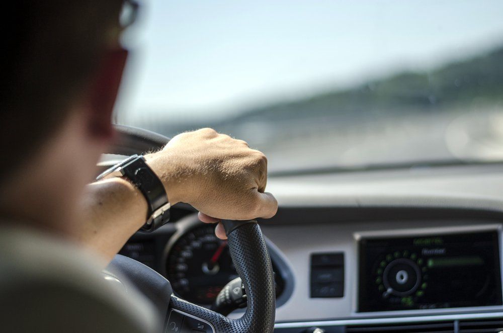 Over The Shoulder View Of A Man Driving Car One Handed - Cairns Traffic Lawyers, Cairns QLD
