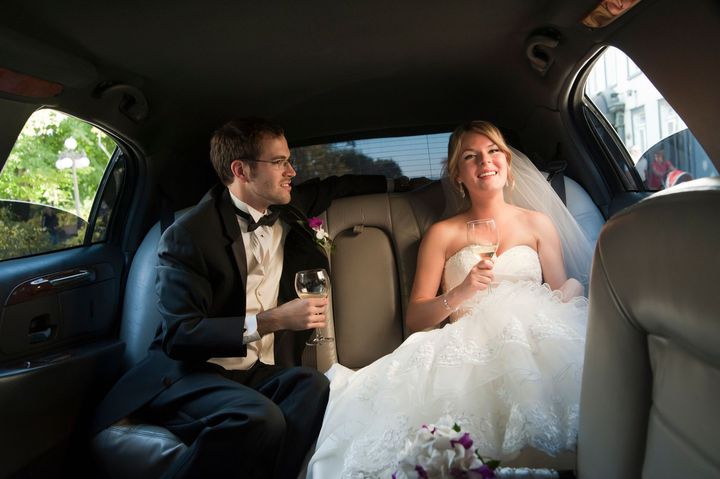 A bride and groom are sitting in the back seat of a limousine. A bride and groom are sitting in the back seat of a limousine.