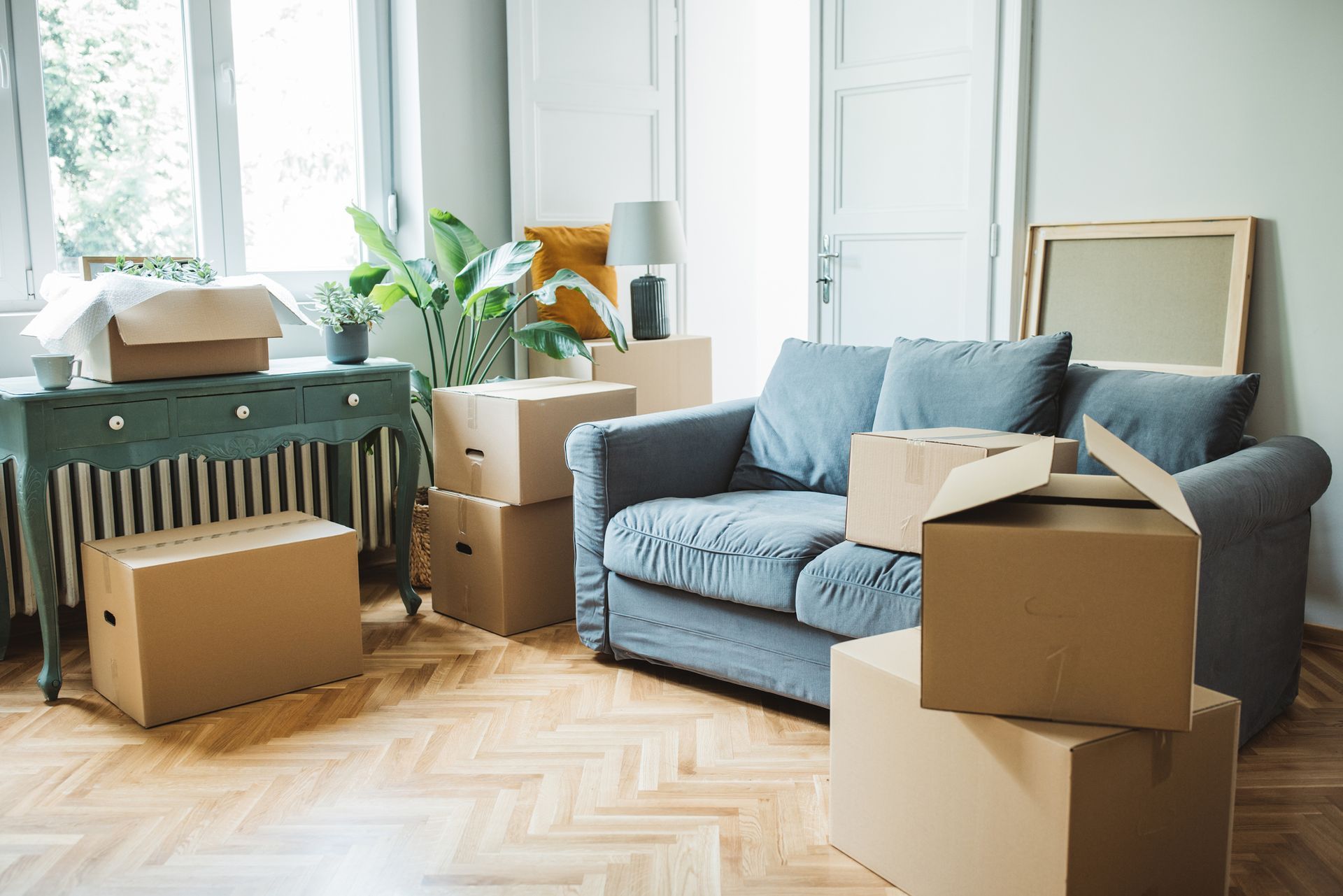 A living room filled with cardboard boxes and a couch.