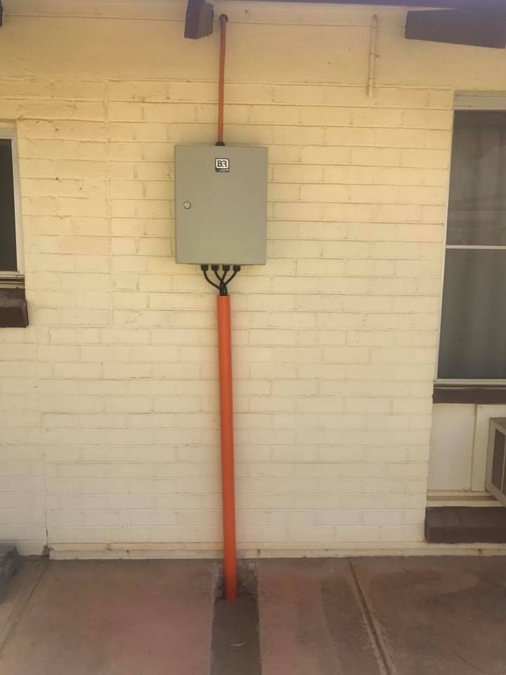 A White Brick Wall With A Box On It And An Orange Pole — Joytech In Ciccone, NT